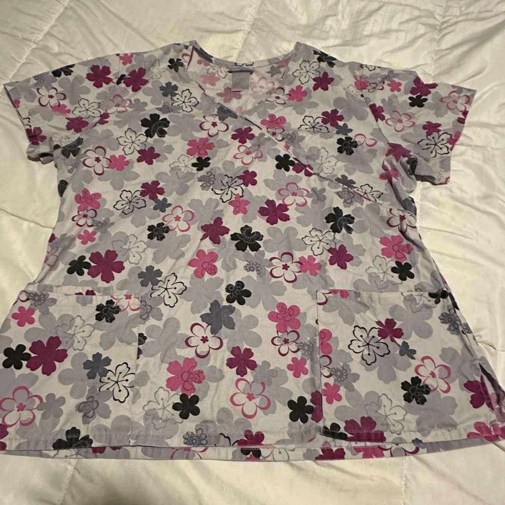 Floral print scrub top. Front pockets, back draw string. Size Large